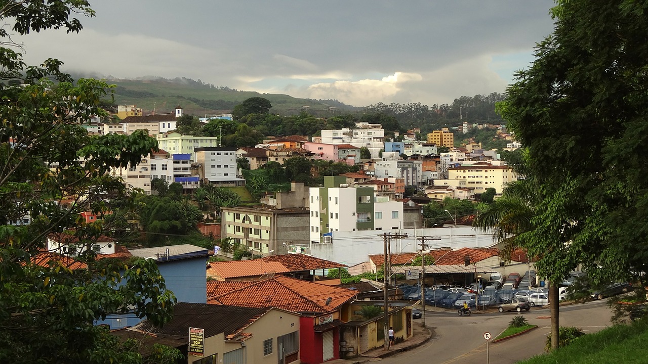 Foto vista panorâmica da cidade de Itabira, Minas Gerais. Casas e prédios pequenos e, ao fundo, um morro.